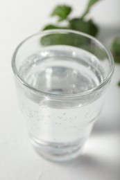 Photo of Glass of soda water on white table, closeup