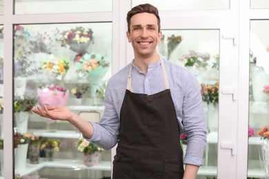 Handsome male florist in apron at workplace