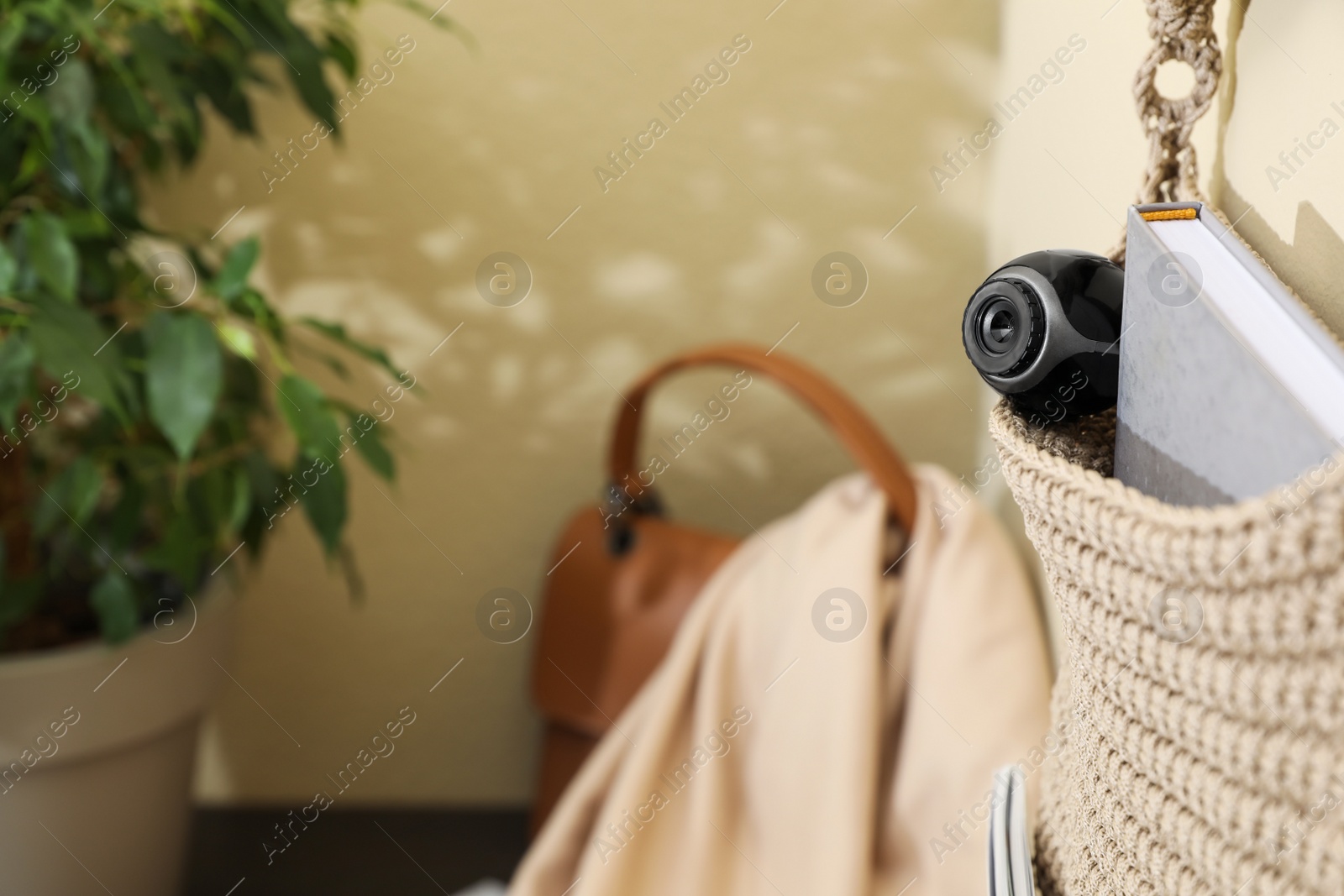 Photo of Hanging storage with small hidden camera on wall in room