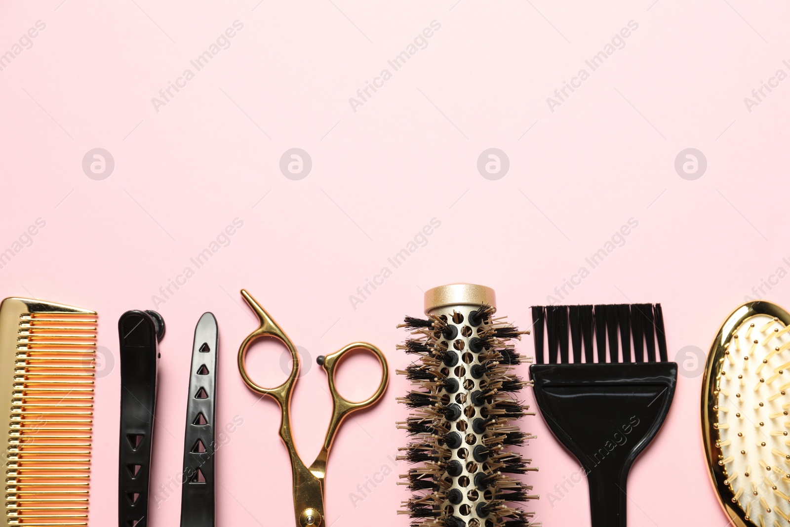 Photo of Professional hair dresser tools on pink background, flat lay. Space for text