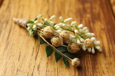 Photo of Small stylish boutonniere on wooden table, closeup