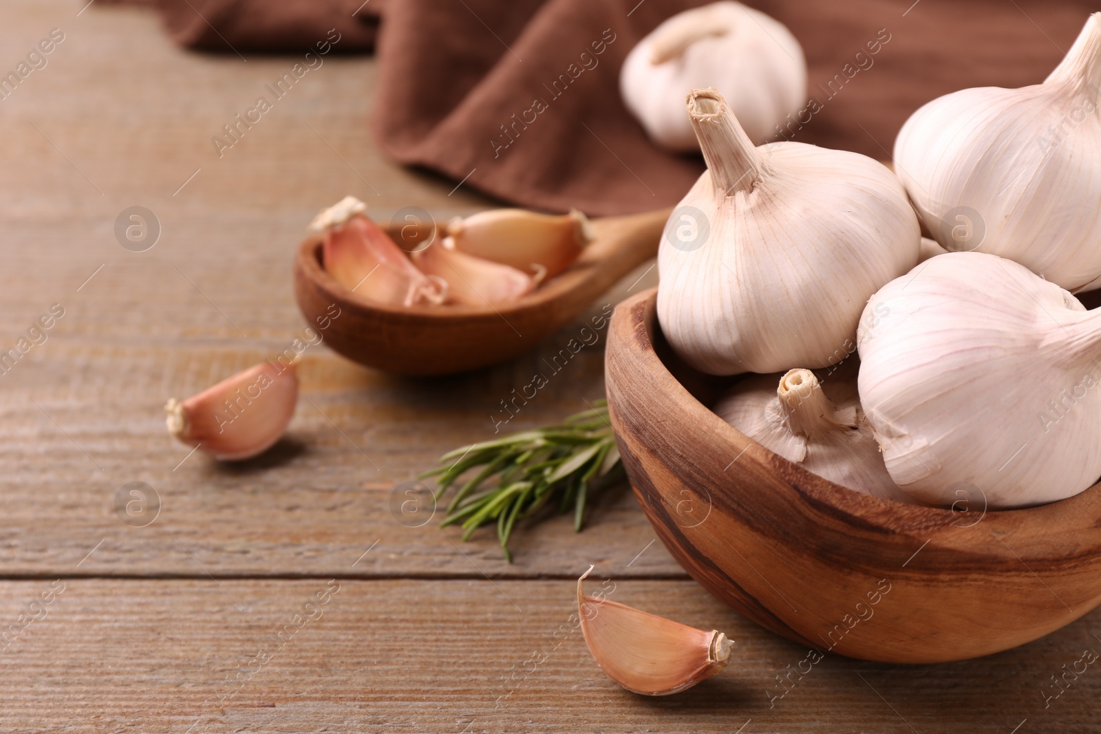 Photo of Fresh garlic on wooden table, closeup. Space for text