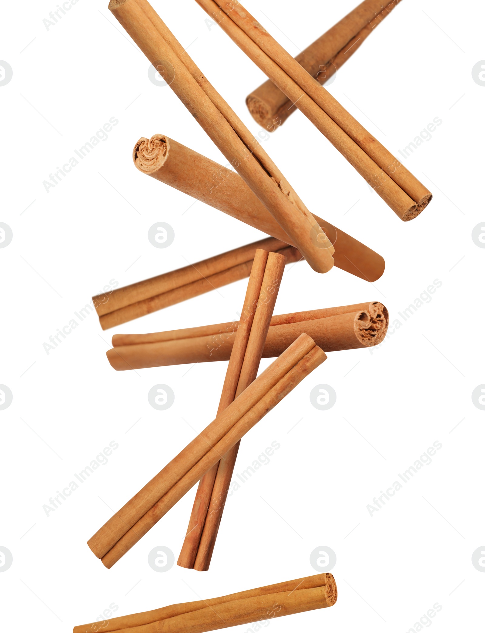 Image of Aromatic cinnamon sticks falling on white background 