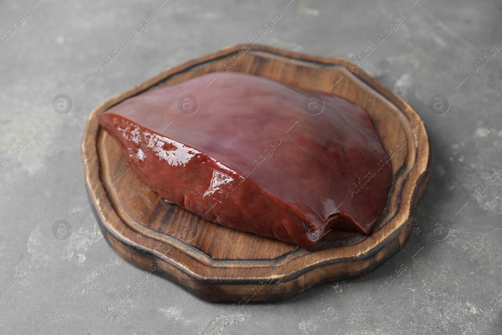 Photo of Piece of raw beef liver on grey table