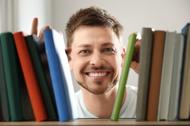 Photo of Man searching for book on shelf in library