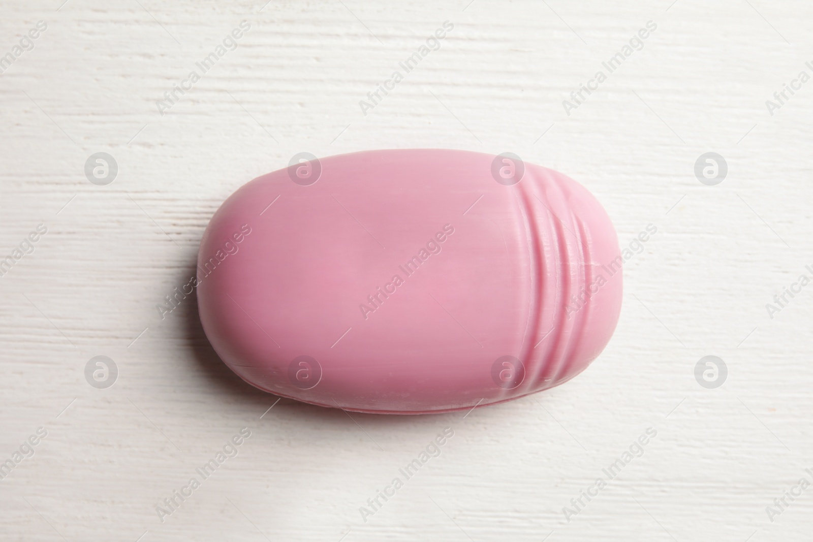 Photo of Soap bar on white wooden background, top view