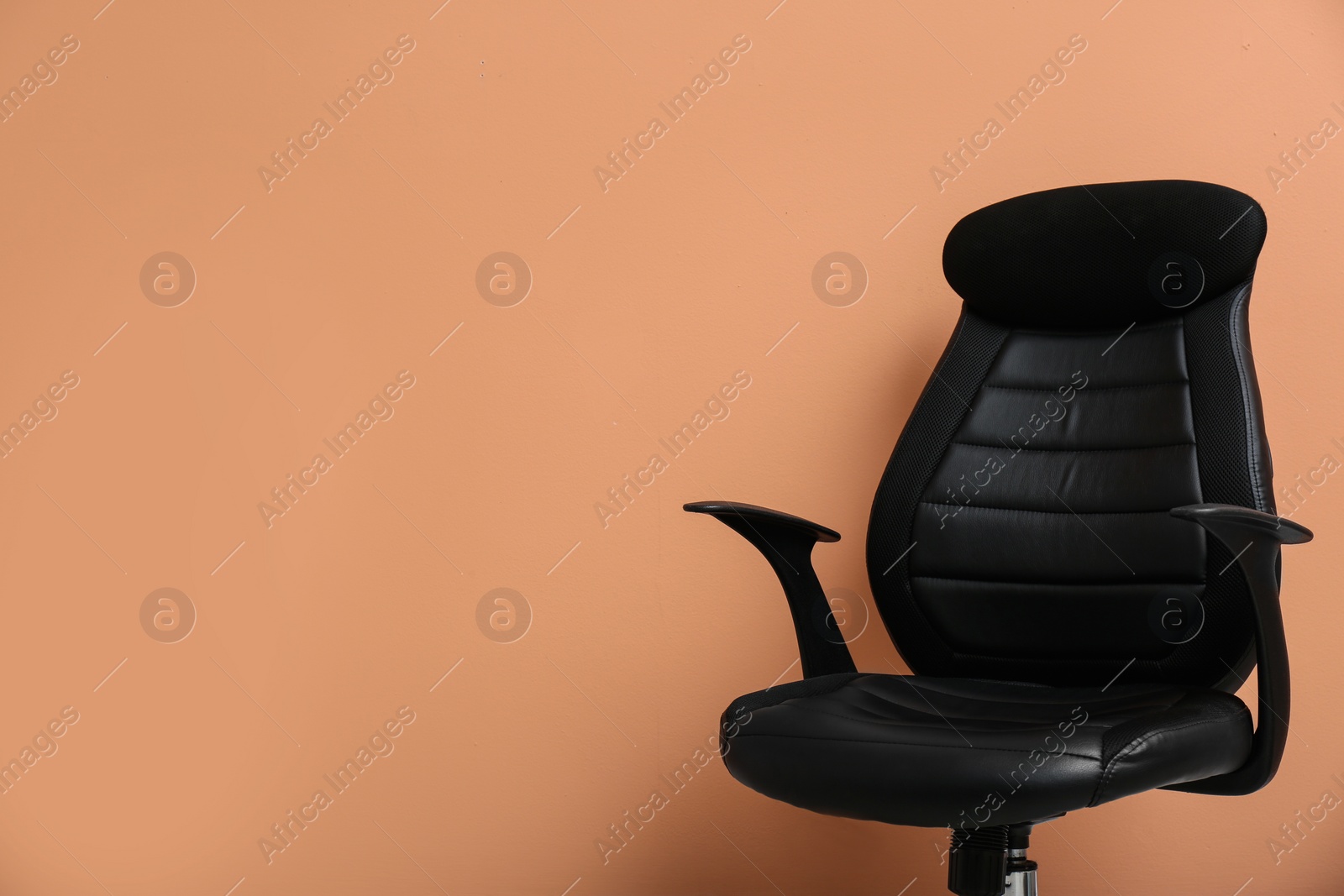 Photo of Modern office chair on orange coral background. Space for text