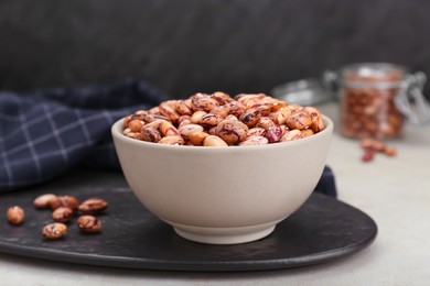 Bowl with dry kidney beans on table, closeup