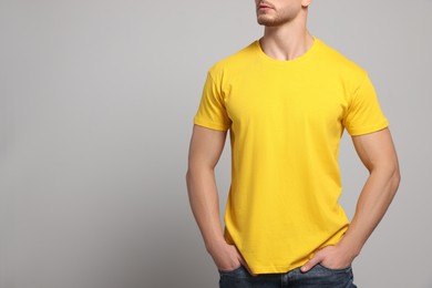 Photo of Man wearing yellow t-shirt on light grey background, closeup. Mockup for design