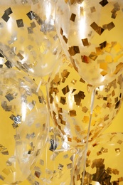 Photo of Balloons with sparkles on color background, closeup