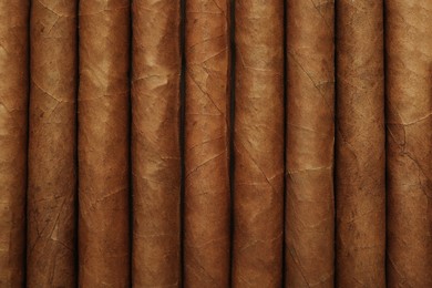 Photo of Closeup of many cigars as background, top view