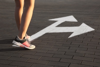 Photo of Woman going along road with arrows marking, closeup