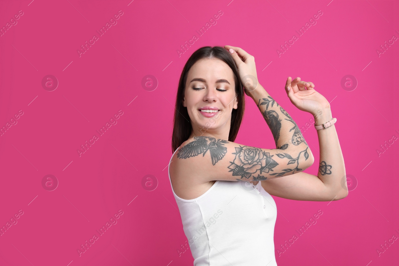 Photo of Beautiful woman with tattoos on arms against pink background. Space for text