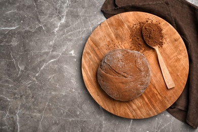 Photo of Flat lay composition with fresh dough and cocoa powder on table