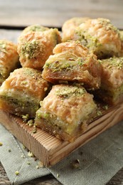 Photo of Delicious fresh baklava with chopped nuts on table, closeup. Eastern sweets