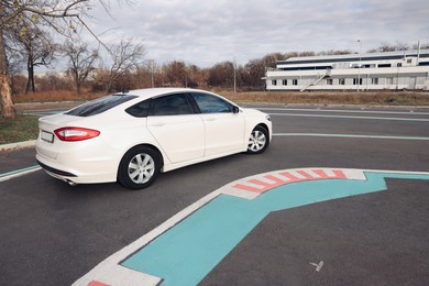 Photo of Modern car on test track with marking lines. Driving school