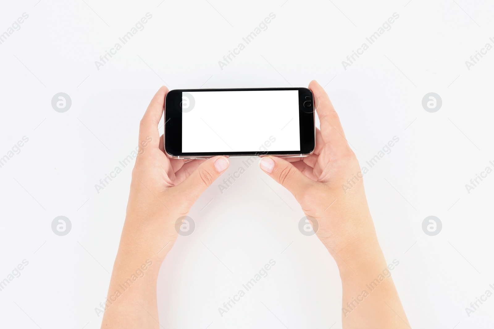 Photo of Young woman holding mobile phone with blank screen in hands on white background