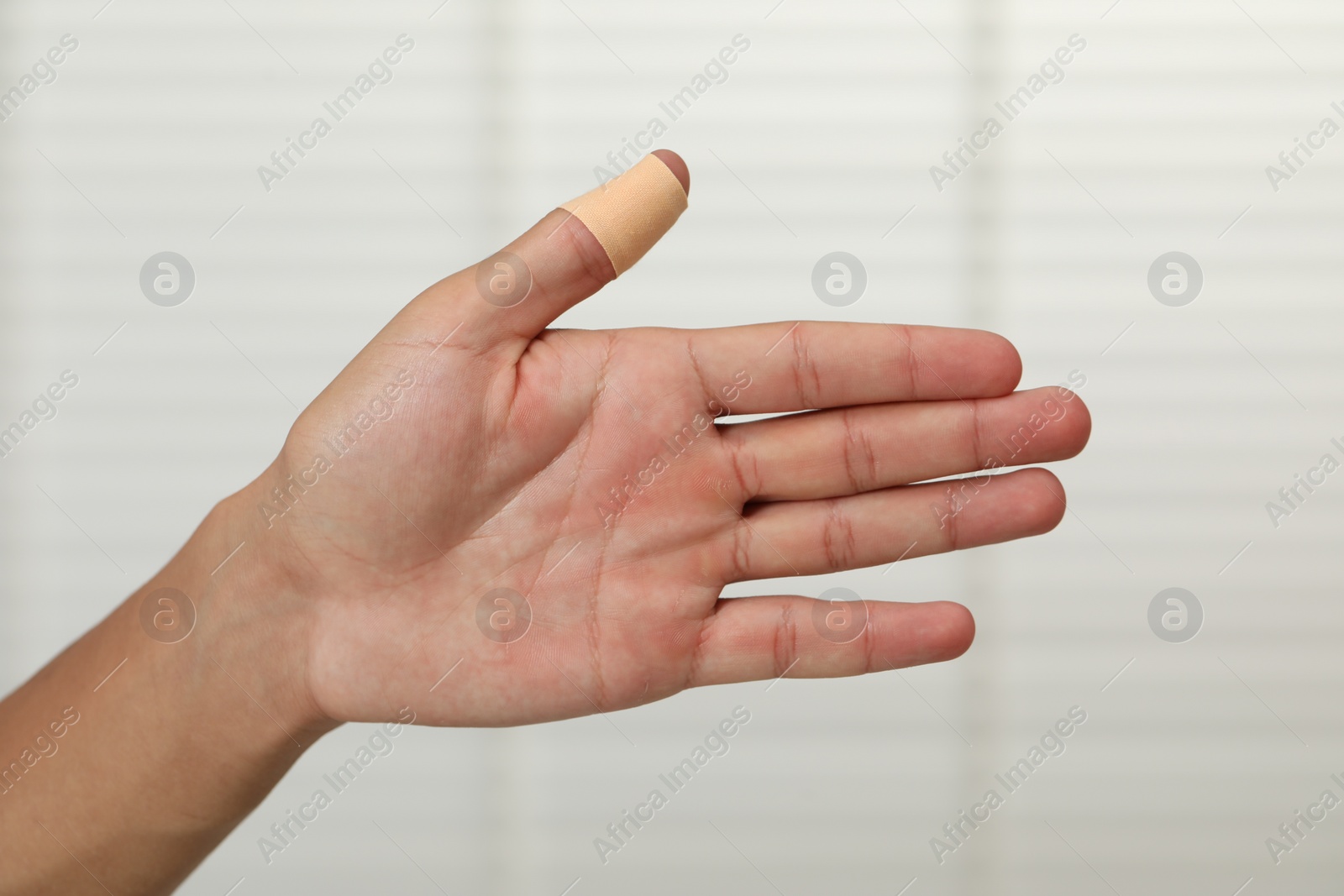 Photo of Man with sticking plaster on his thumb indoors, closeup