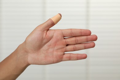 Photo of Man with sticking plaster on his thumb indoors, closeup