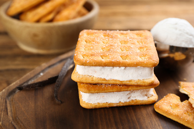 Photo of Sweet delicious ice cream cookie sandwiches on wooden board, closeup