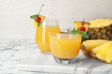 Photo of Glasses with delicious pineapple juice on table