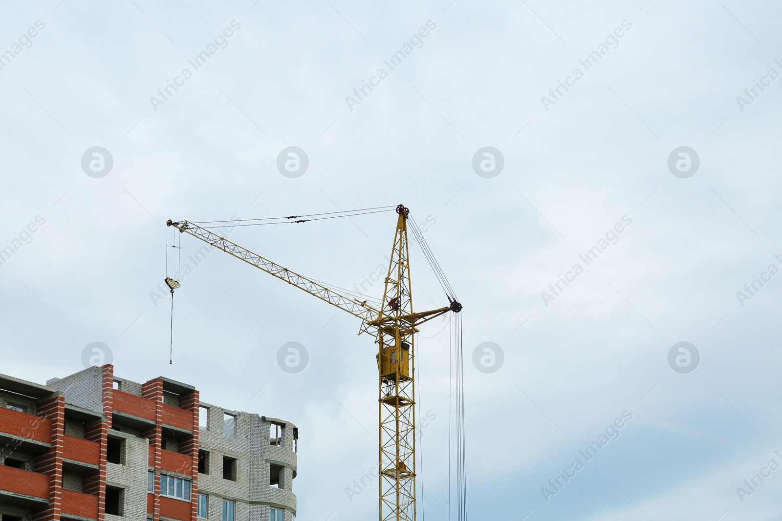 Photo of Modern tower crane against cloudless sky. Construction site