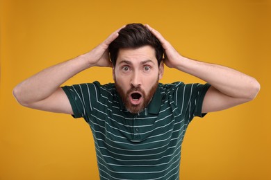 Photo of Portrait of surprised man on yellow background