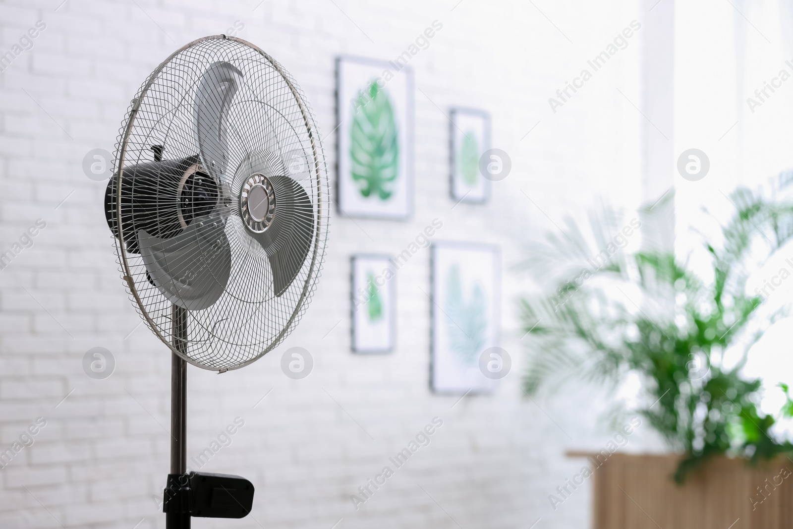 Photo of Modern electric fan in room. Space for text