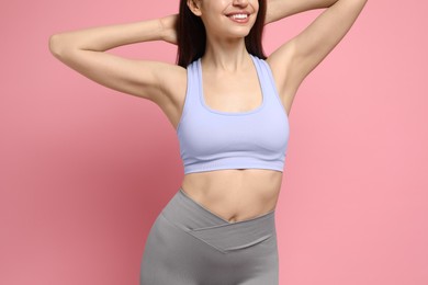 Photo of Woman with slim body posing on pink background, closeup
