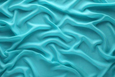 Photo of Beautiful turquoise tulle fabric as background, top view