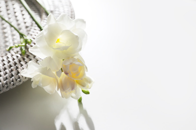 Beautiful freesia flowers on white table, closeup. Space for text