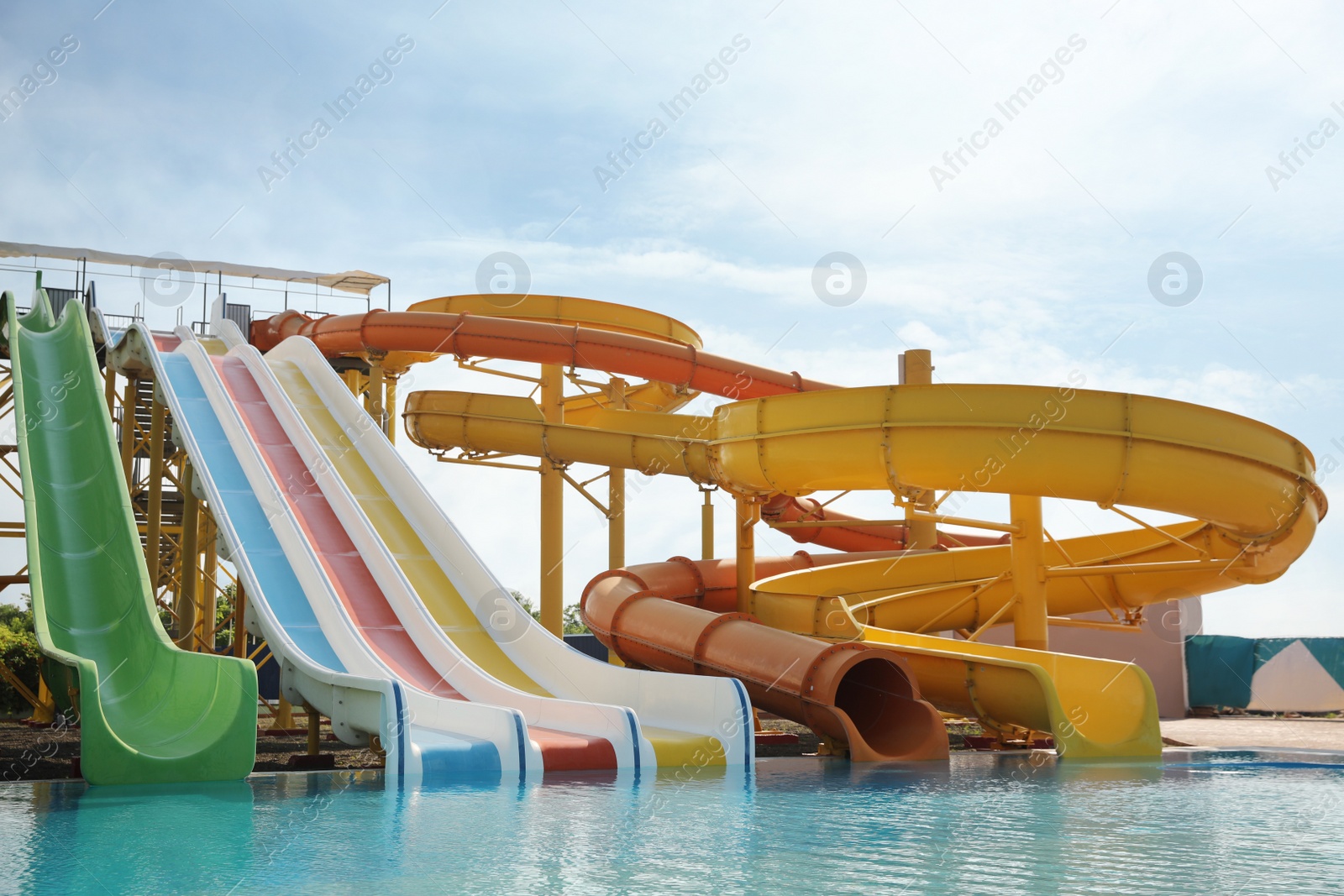 Photo of Beautiful view of water park with colorful slides and swimming pool on sunny day