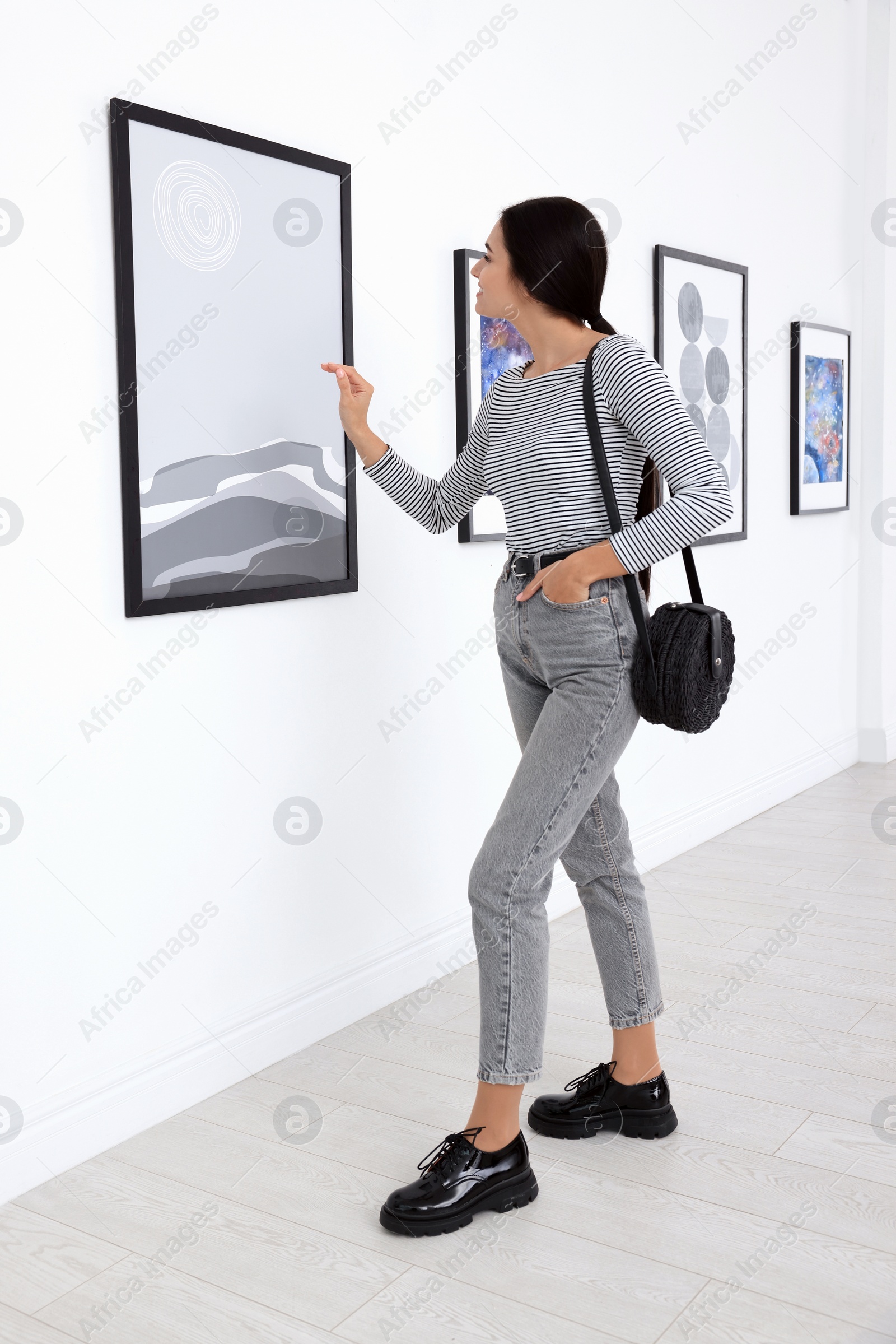 Photo of Happy young woman at exhibition in art gallery