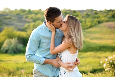 Cute young couple in love posing outdoors on sunny day