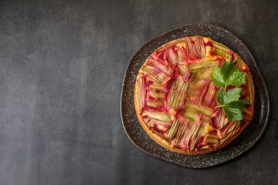 Photo of Freshly baked rhubarb pie on black table, top view. Space for text