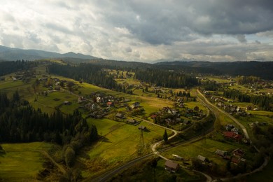 Image of Aerial view of beautiful forest and mountain village on autumn day