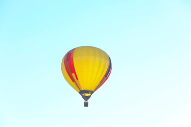 Photo of Colorful hot air balloon flying in blue sky. Space for text
