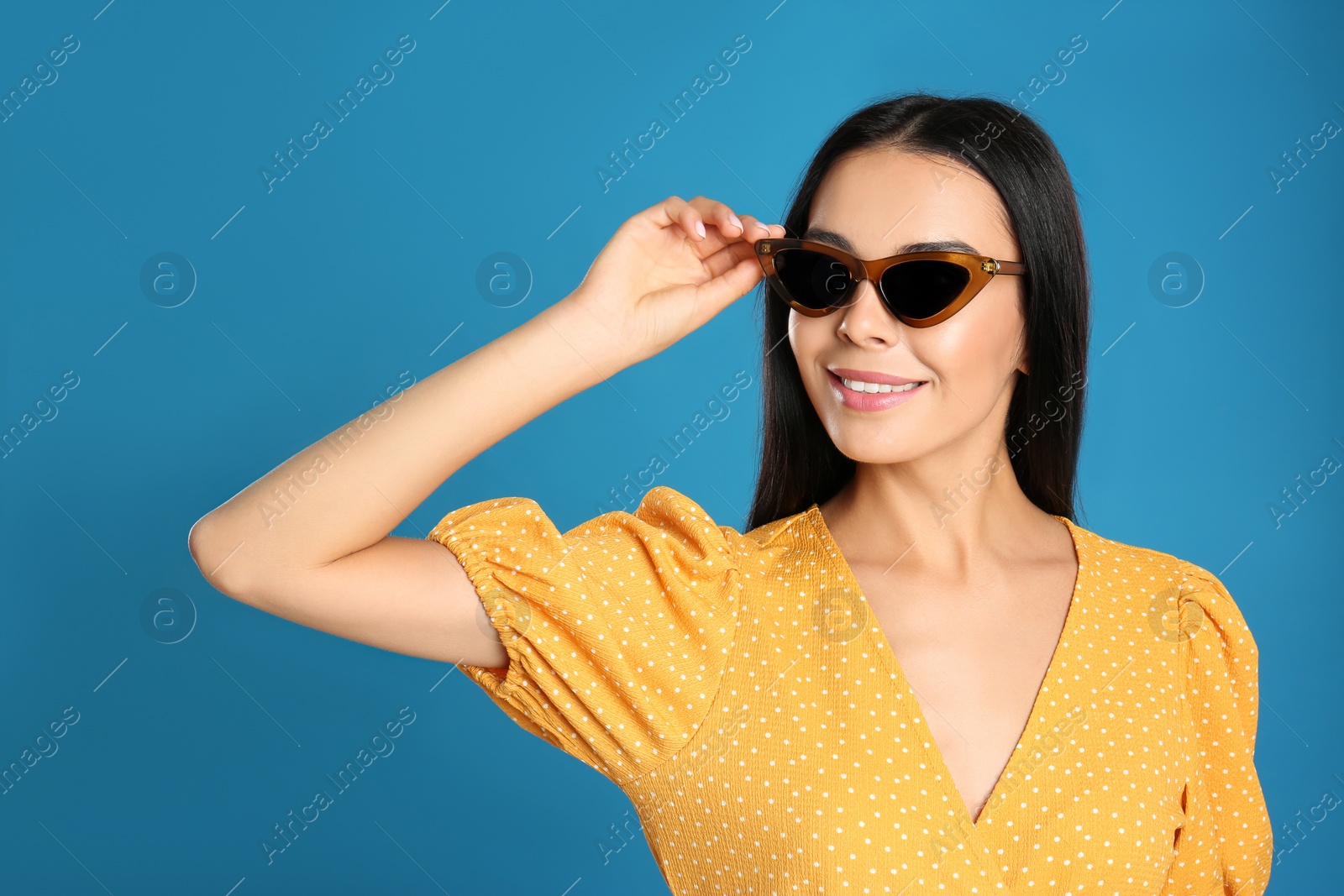 Photo of Beautiful woman wearing sunglasses on blue background