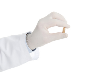 Photo of Doctor holding suppository for hemorrhoid treatment on white background, closeup