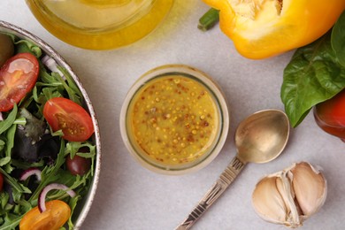 Tasty vinegar based sauce (Vinaigrette) in jar, salad and products on light table, flat lay