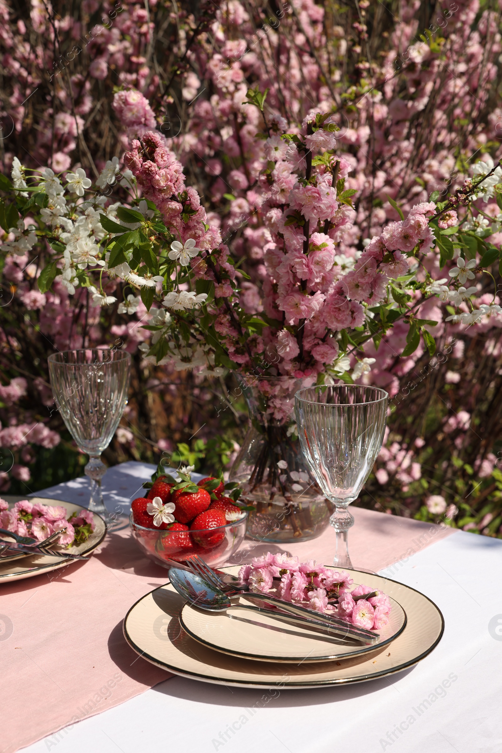 Photo of Stylish table setting with beautiful spring flowers in garden