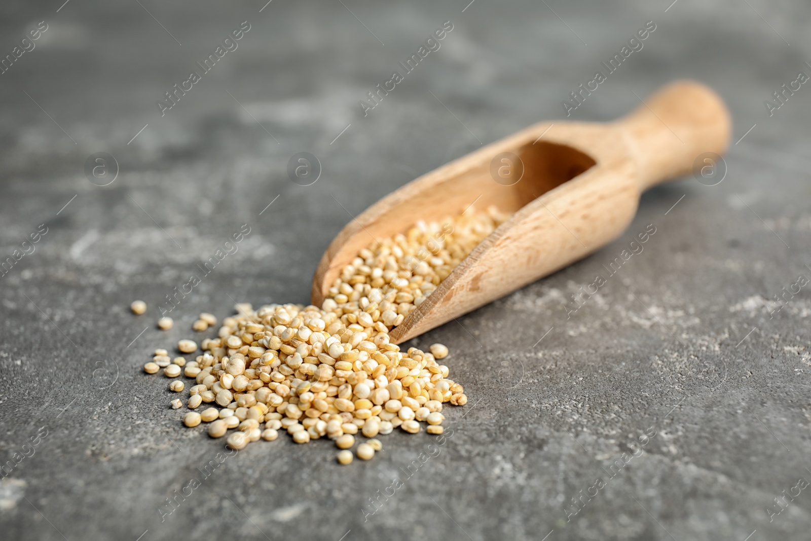 Photo of Scoop with white quinoa on grey background