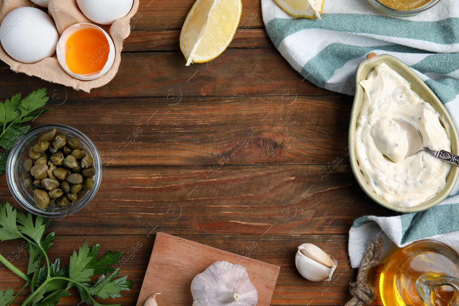 Photo of Tasty tartar sauce and ingredients on wooden table, flat lay. Space for text