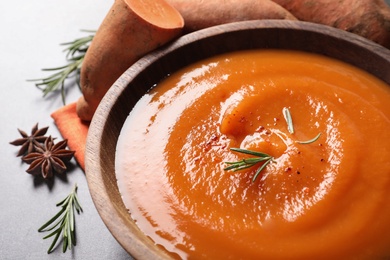 Photo of Bowl of tasty sweet potato soup on table, closeup