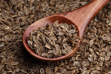 Photo of Dry dill seeds and wooden spoon, closeup