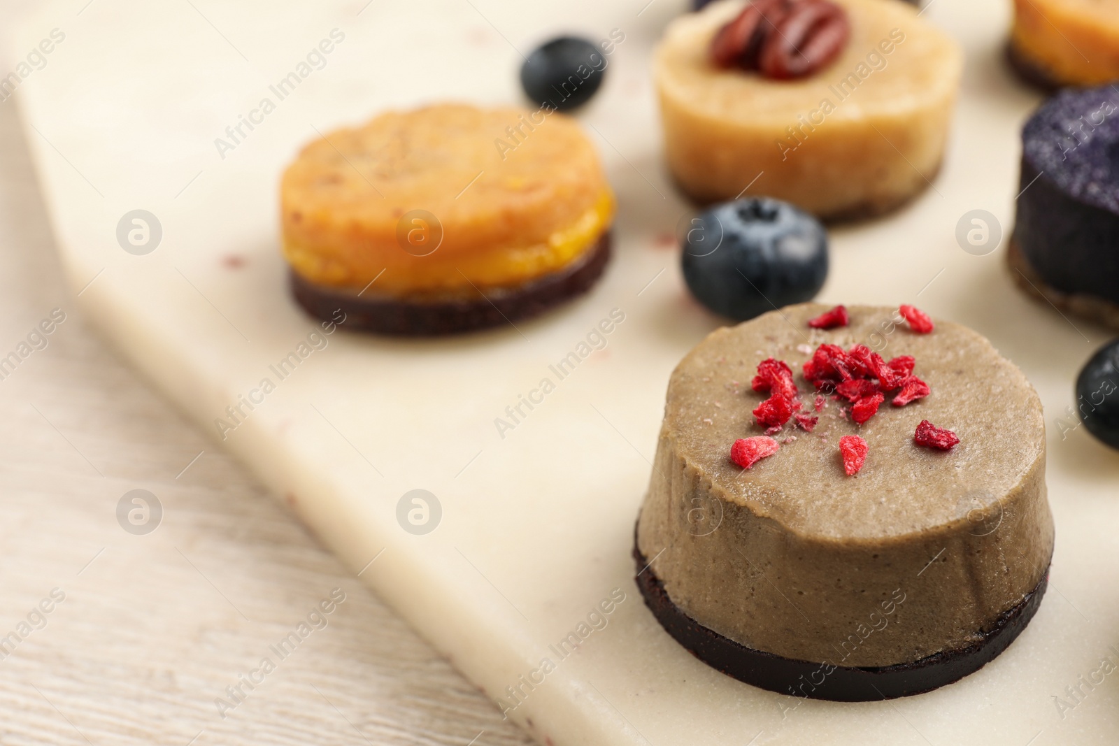 Photo of Different delicious vegan candies on board, closeup