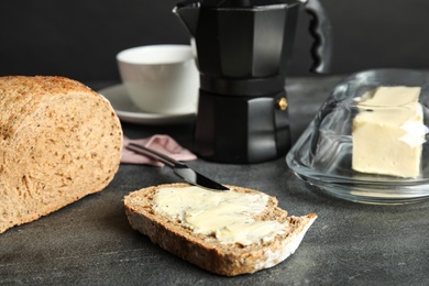 Photo of Slice of bread with tasty butter for breakfast on dark table