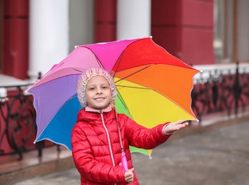 Photo of Little girl with umbrella in city on autumn rainy day
