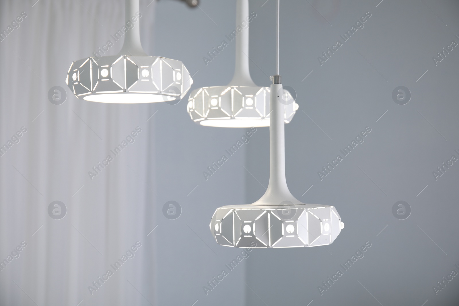 Photo of Stylish white pendant lamp in light room