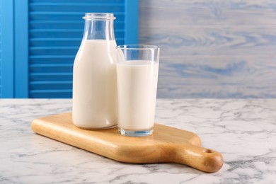 Glassware with tasty milk on white marble table